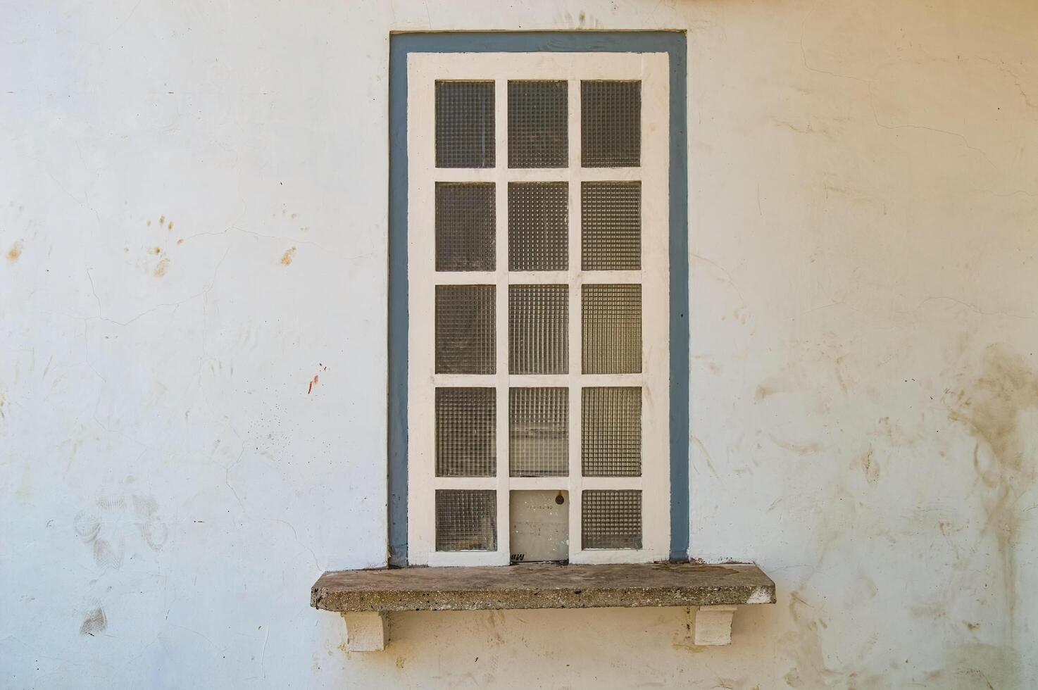 un blanco estilo griego de madera ventana ese estaba previamente usado como un mostrador en un antiguo edificio ese es ahora No más extenso usado foto