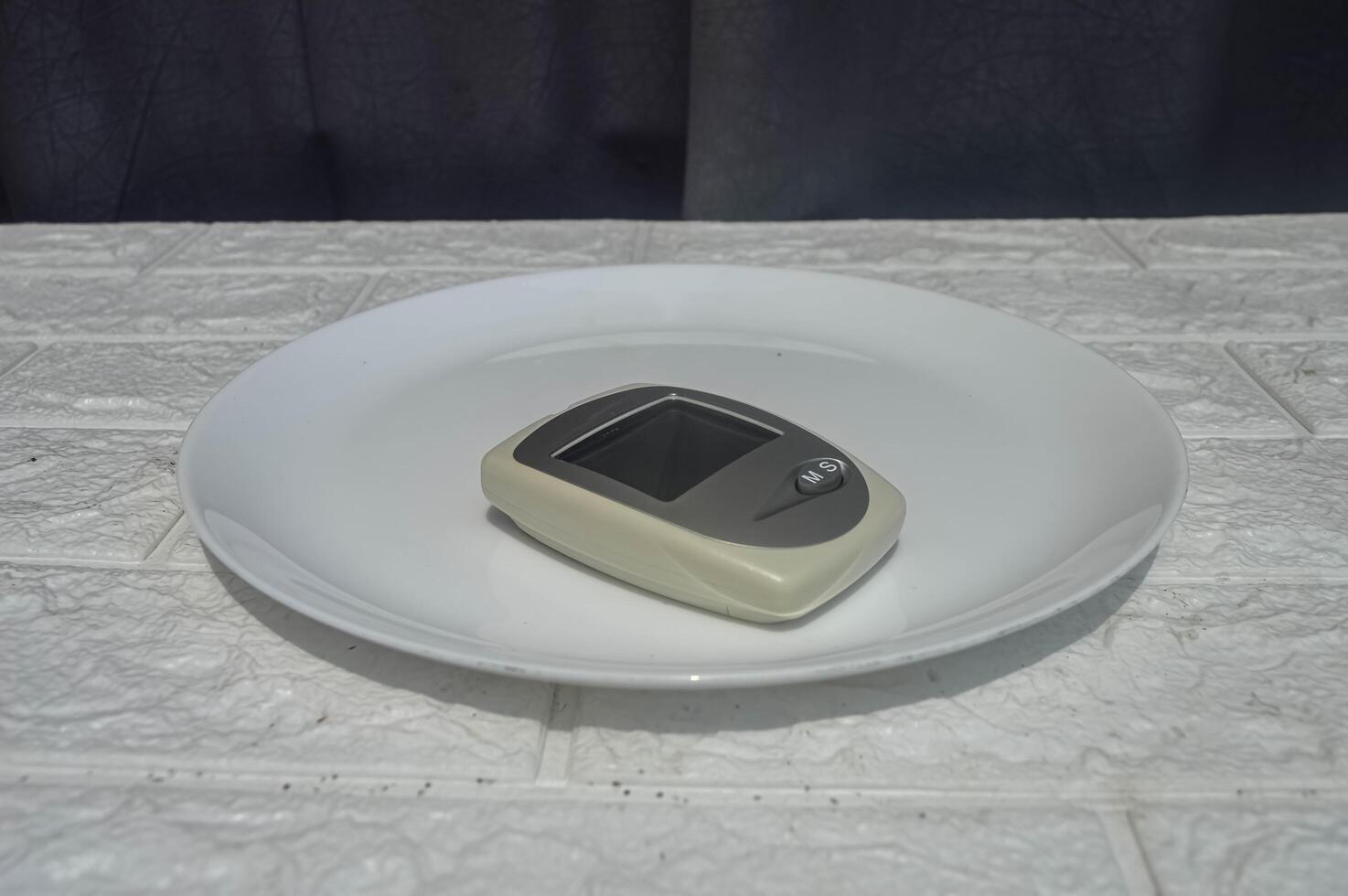 test tool for glucose, cholesterol and uric acid levels on a dinner plate photo