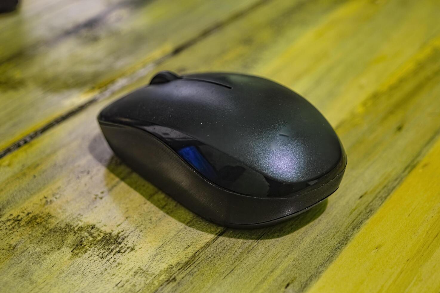 a black wireless mouse on a wooden table photo