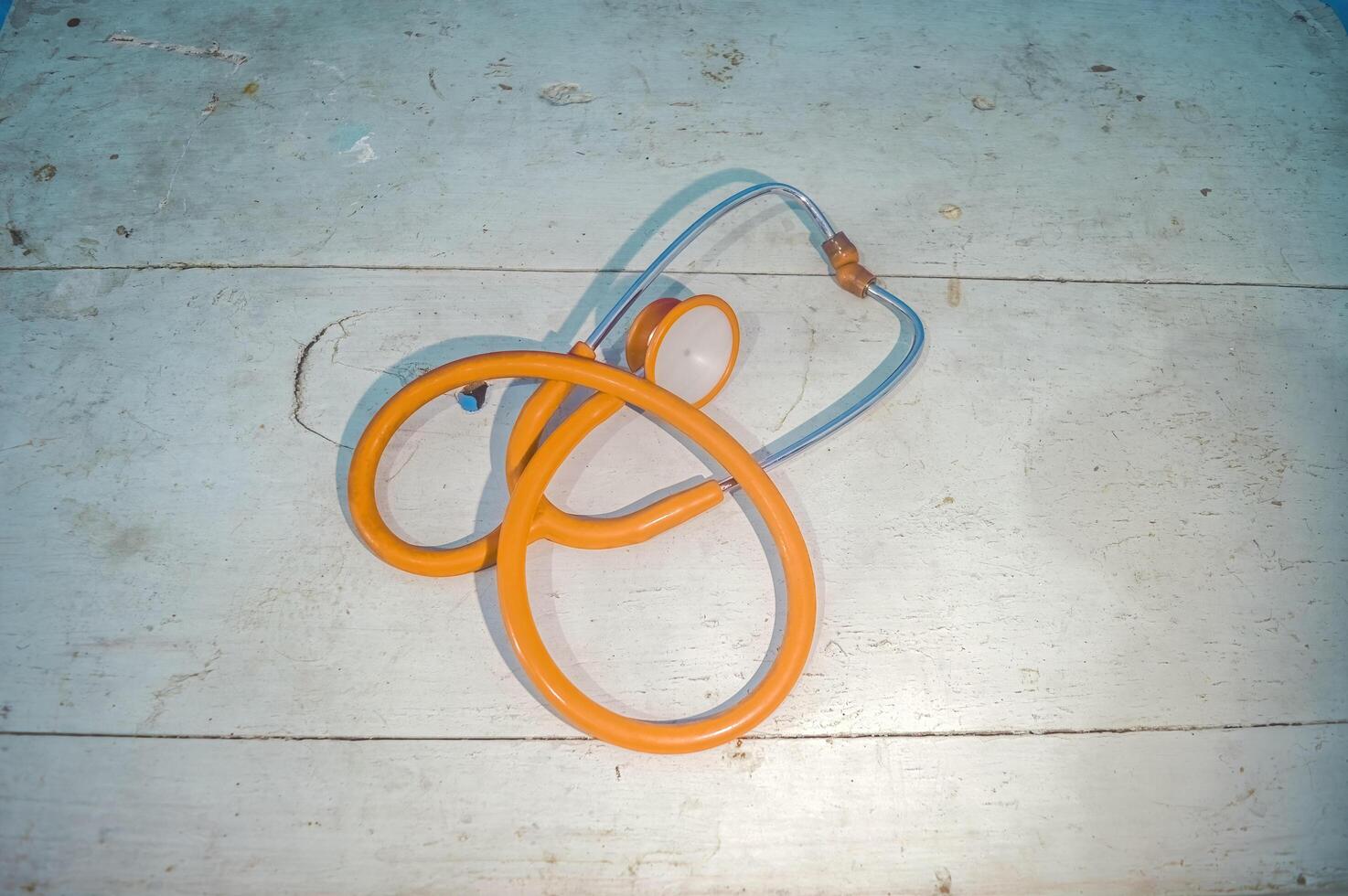 A yellow stethoscope on a wooden table photo