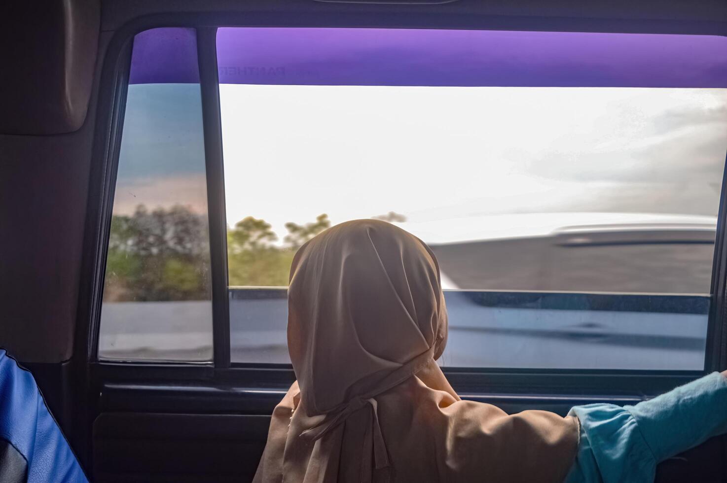 a child looking out the car window while traveling photo