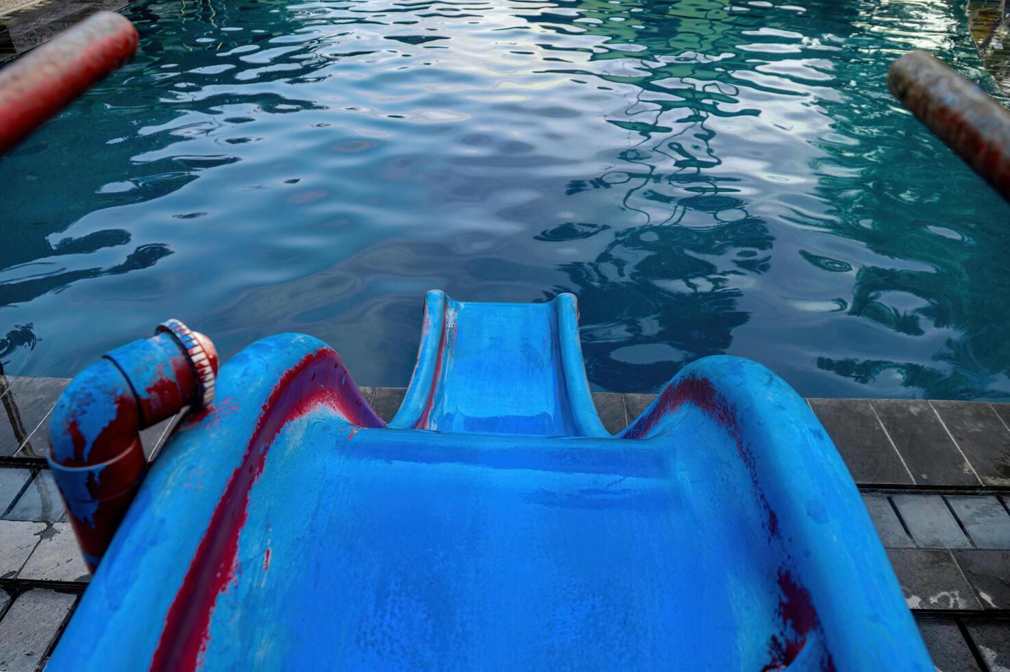point of view of people going down a slide towards the swimming pool photo