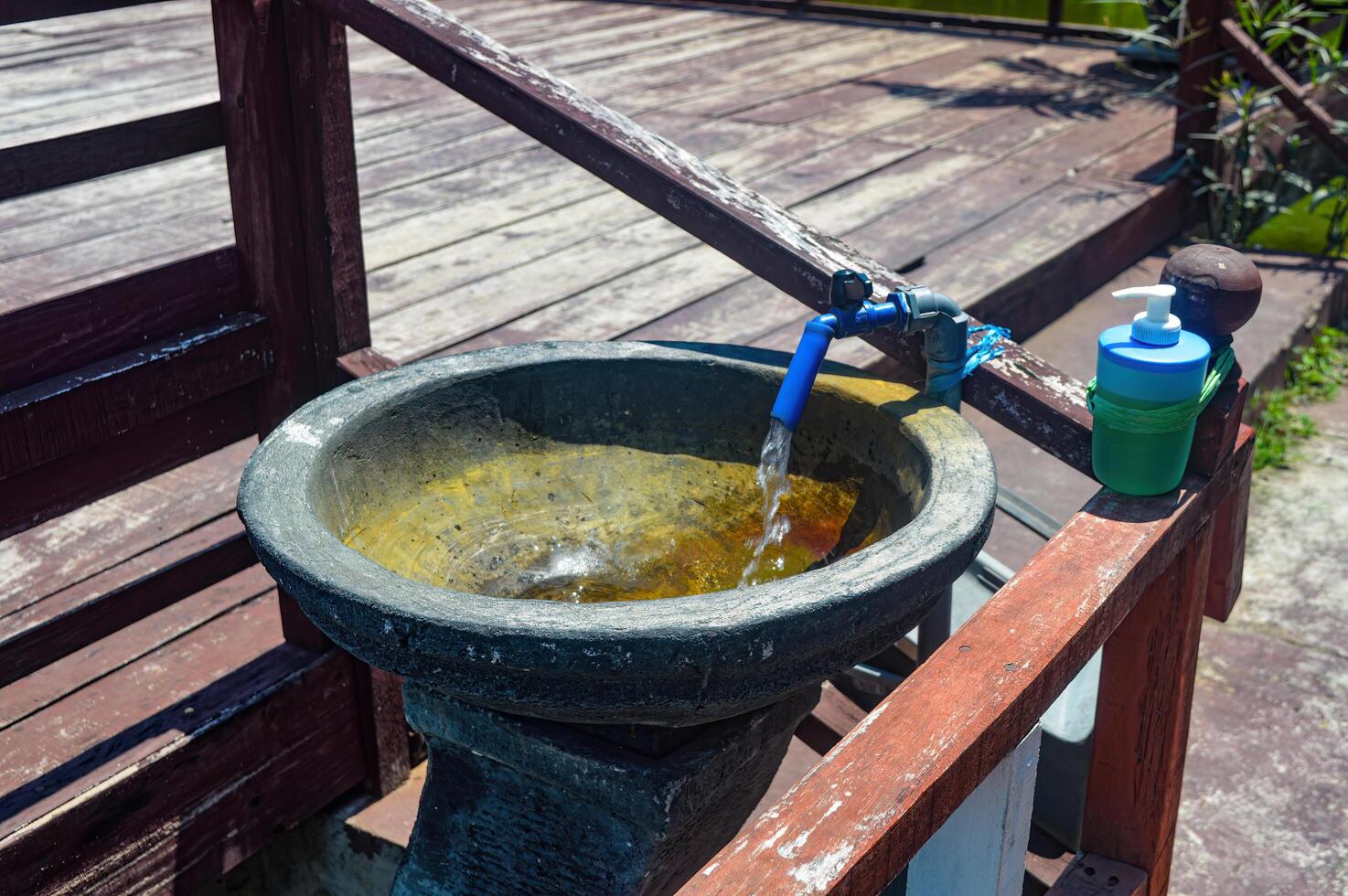 stone sink with water faucet with water pouring out photo