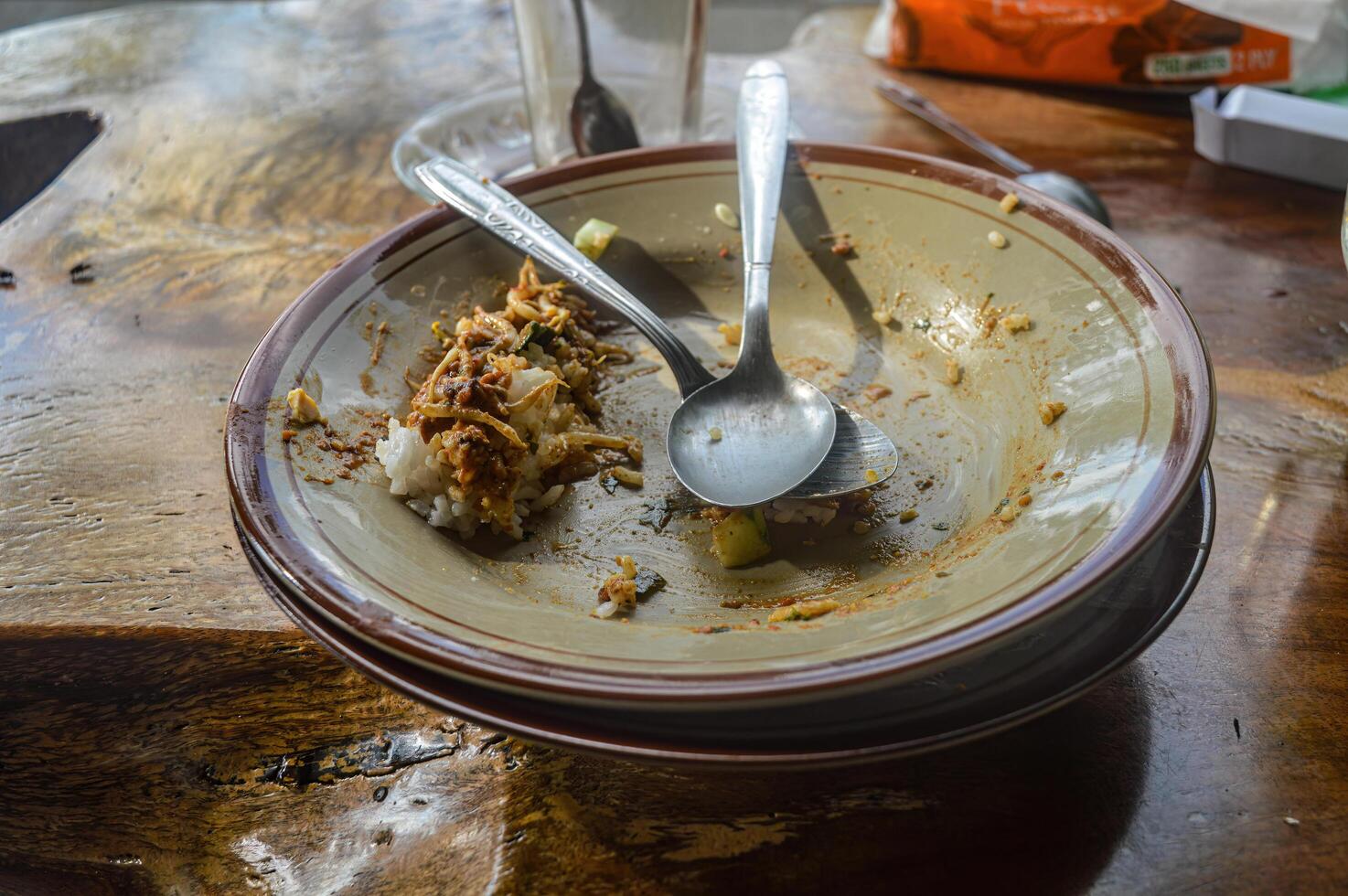 un plato de sobras con dos cucharas apilado en parte superior foto