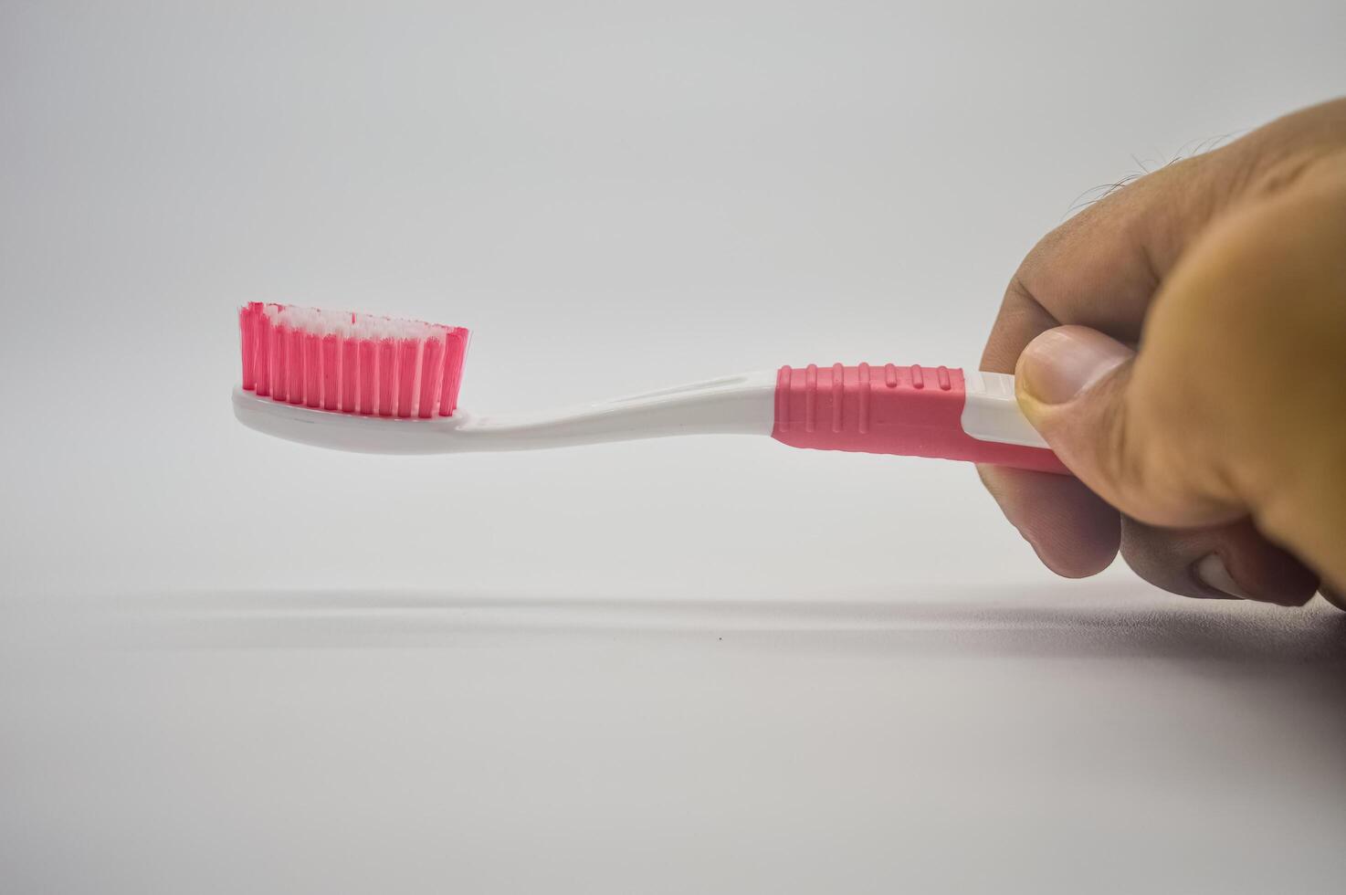 mano participación un cepillo de dientes, aislado en un blanco antecedentes foto