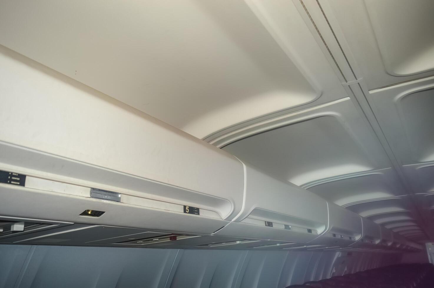 Overhead bin in the aircraft interior for storing passenger luggage photo