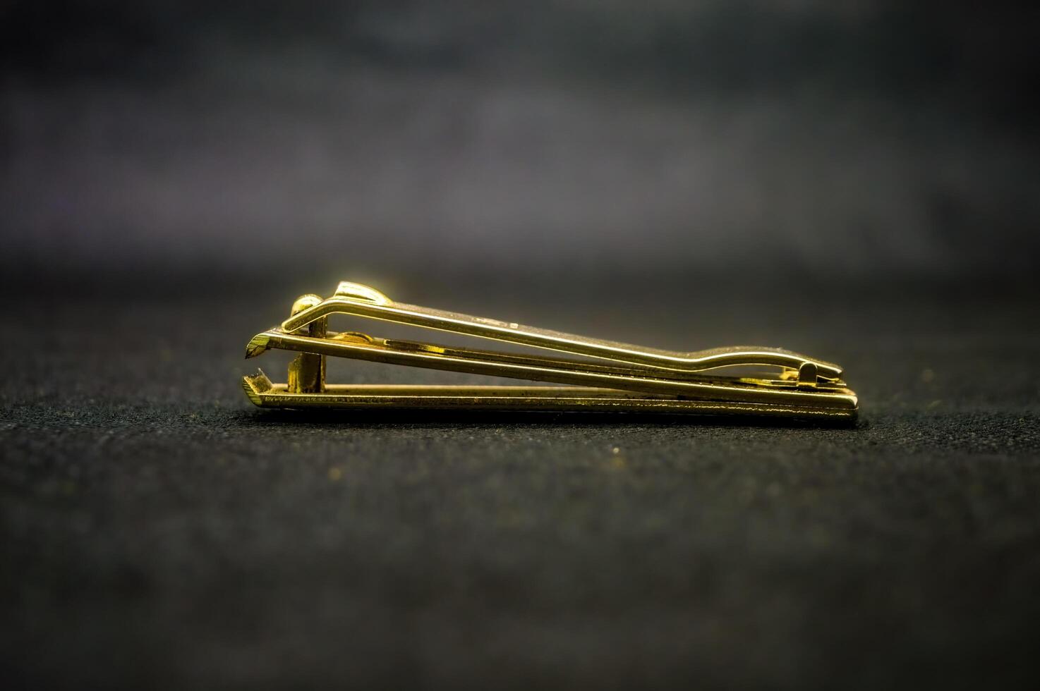 a gold nail clipper isolated on black background photo