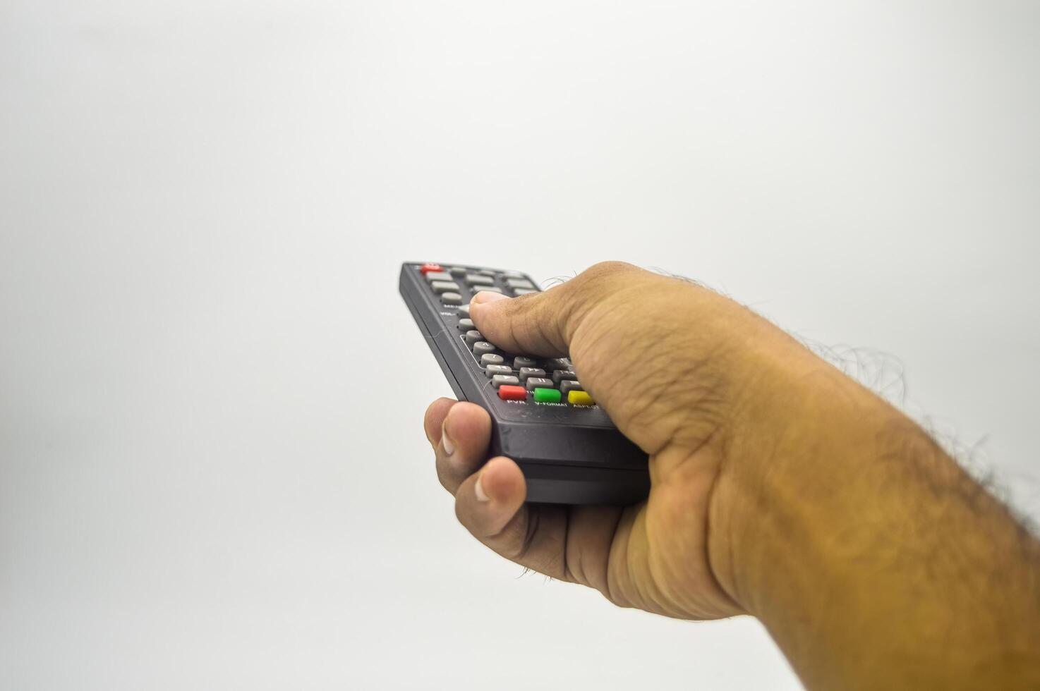 The hand is holding the TV remote isolated on white background photo