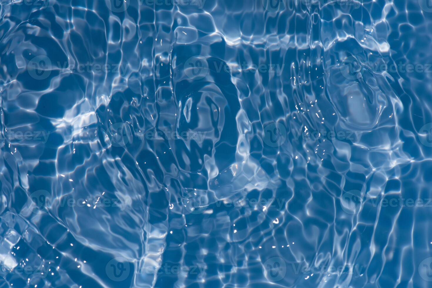 Bluewater waves on the surface ripples blurred. Defocus blurred transparent blue colored clear calm water surface texture with splash and bubbles. Water waves with shining pattern texture background. photo