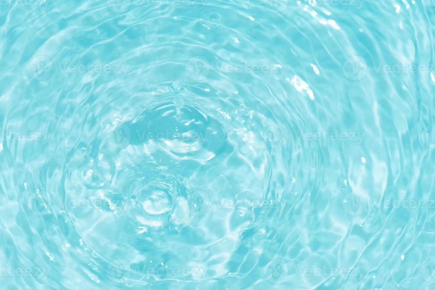 Bluewater waves on the surface ripples blurred. Defocus blurred transparent blue colored clear calm water surface texture with splash and bubbles. Water waves with shining pattern texture background. photo