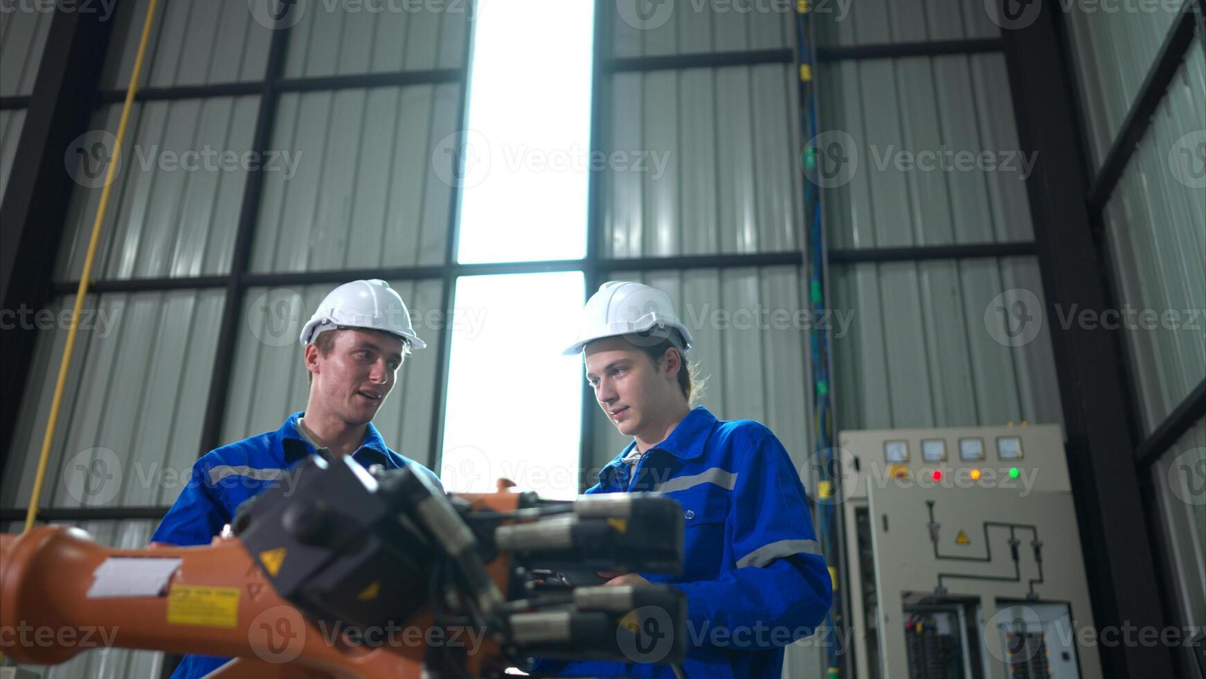 Engineer and technician working with robot arm in factory. Industry and engineering concept. photo