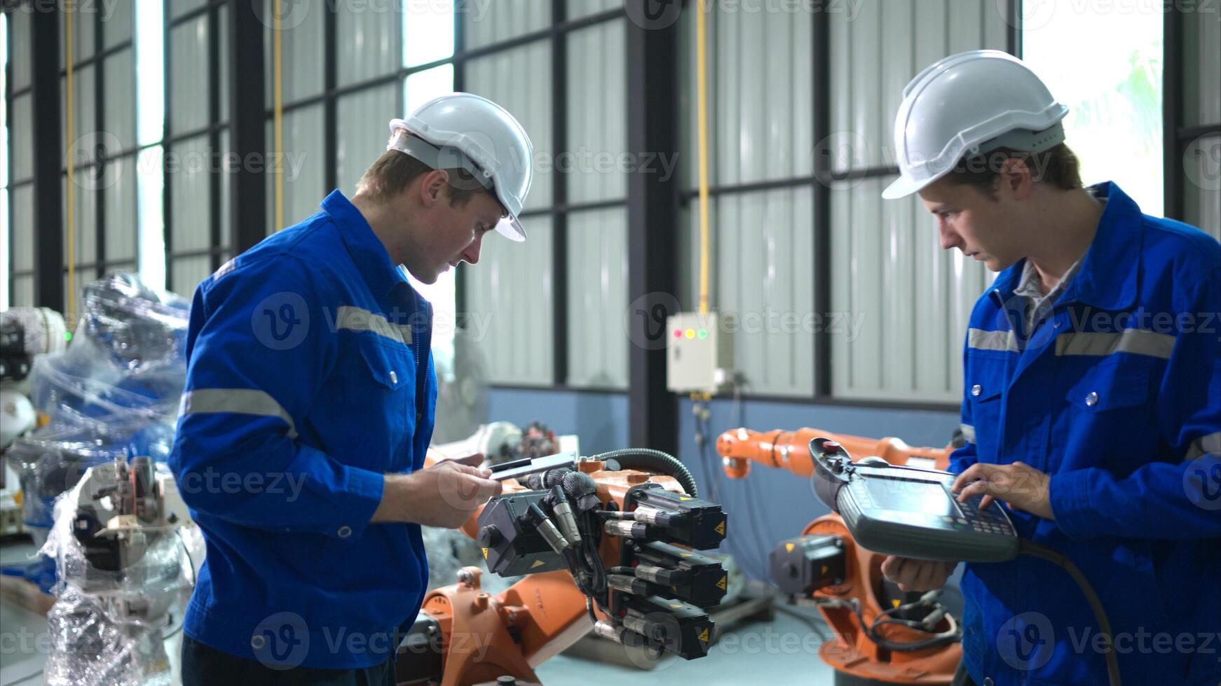 Engineer and technician working with robot arm in factory. Industry and engineering concept. photo