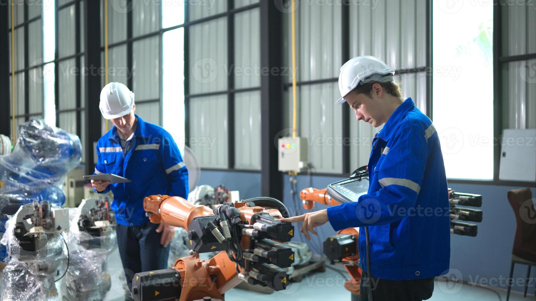 Engineer and technician working with robot arm in factory. Industry and engineering concept. photo