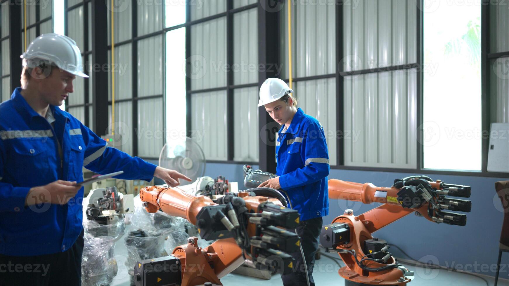 Engineer and technician working with robot arm in factory. Industry and engineering concept. photo