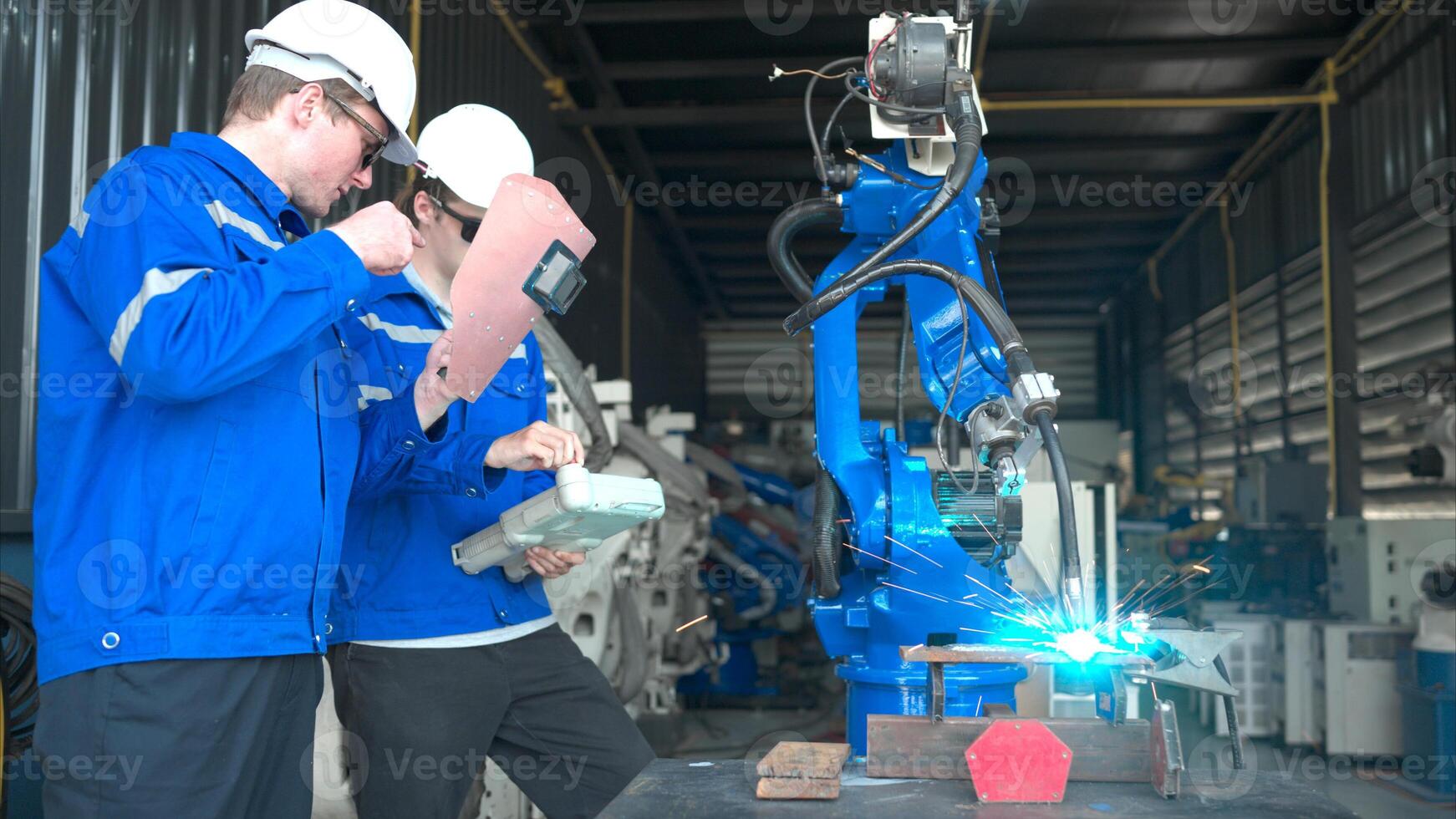 Industrial workers working with robotic arm welding machine in factory, Robotic arm welding industry and engineering concept. photo