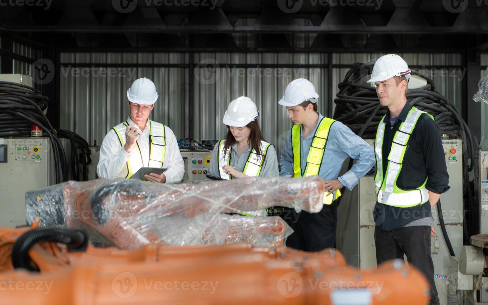 Group of engineers and technicians working together in a robotic arm factory. Inspecting robot arm before delivering to customers photo