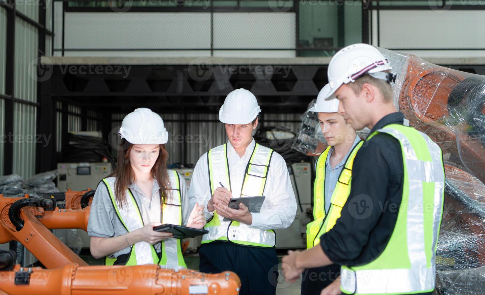 Group of engineers and technicians working together in a robotic arm factory. Inspecting robot arm before delivering to customers photo