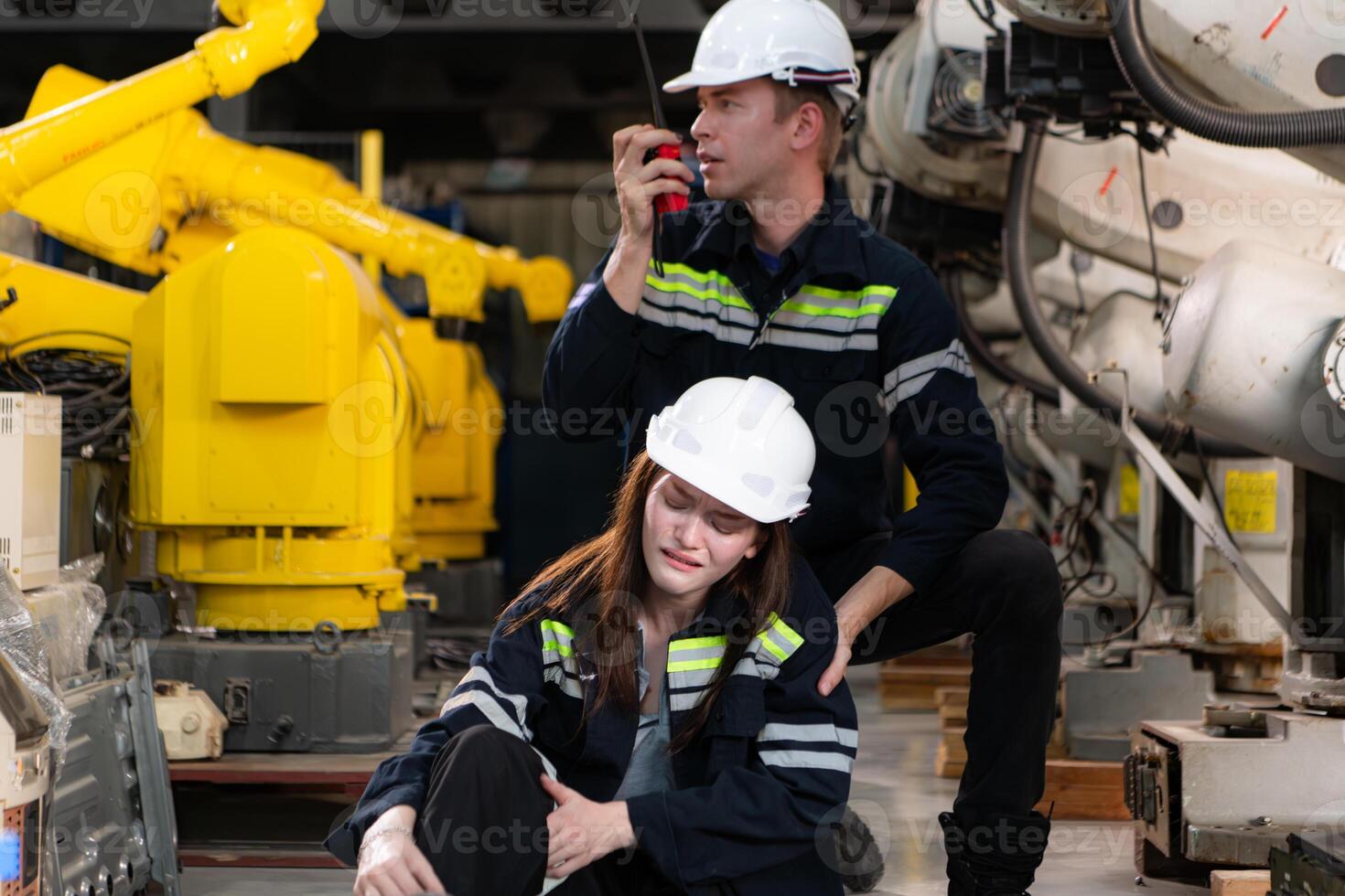 A female worker suffered a leg accident while working in robotic arms factory and male technician asking for first aid assistance photo