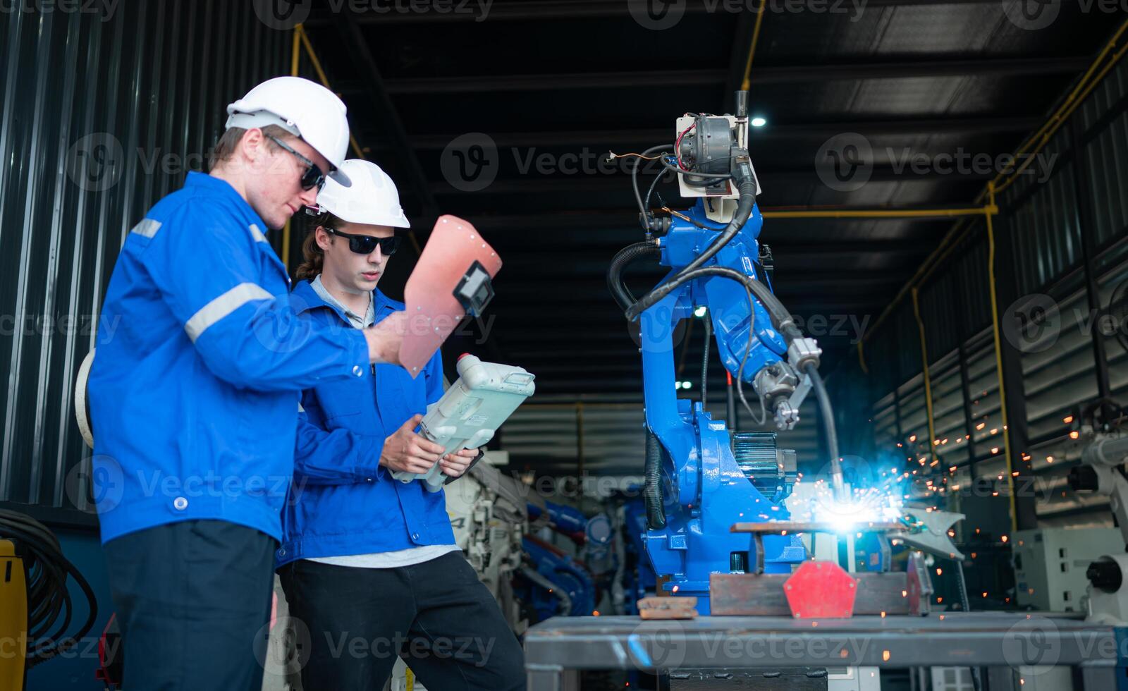 Industrial workers working with robotic arm welding machine in factory, Robotic arm welding industry and engineering concept. photo