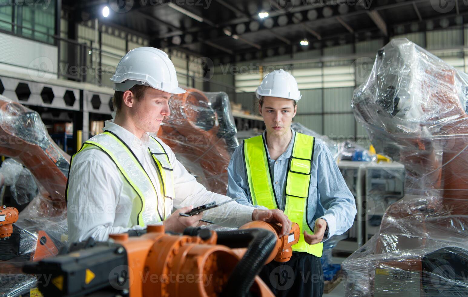 Both of engineers working together in a robotic arm factory, Robotic arm industry and engineering concept. photo