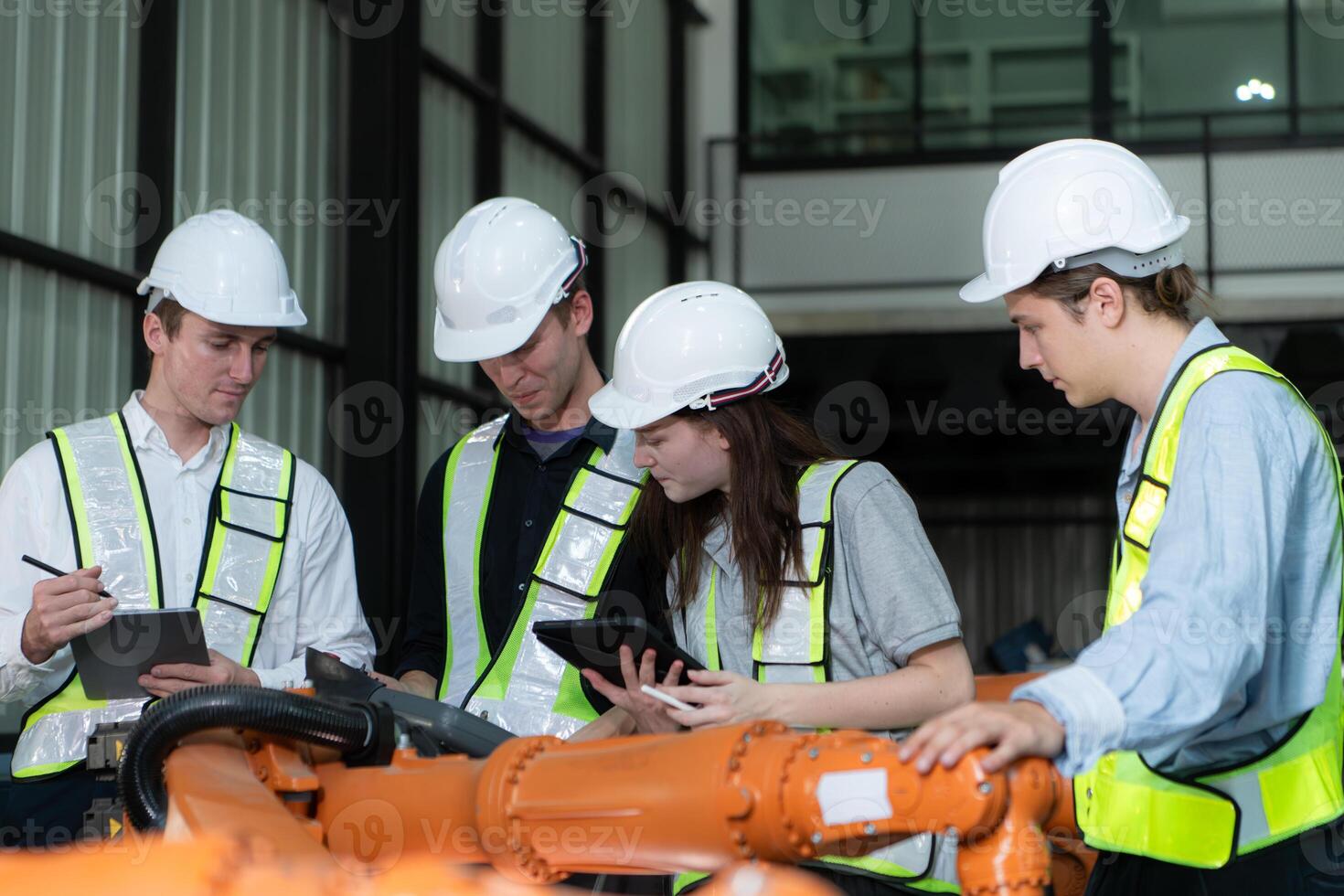 Group of engineers and technicians working together in a robotic arm factory. Inspecting robot arm before delivering to customers photo