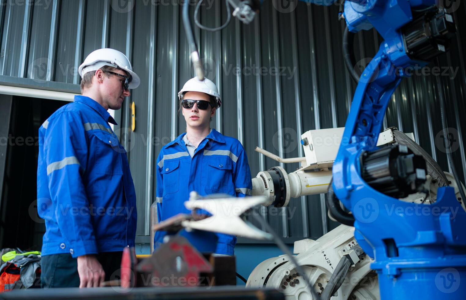 Industrial workers working with robotic arm welding machine in factory, Robotic arm welding industry and engineering concept. photo
