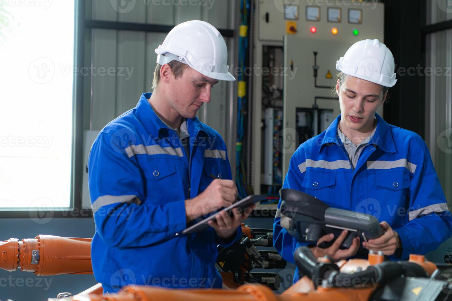 Engineer and technician working with robot arm in factory. Industry and engineering concept. photo