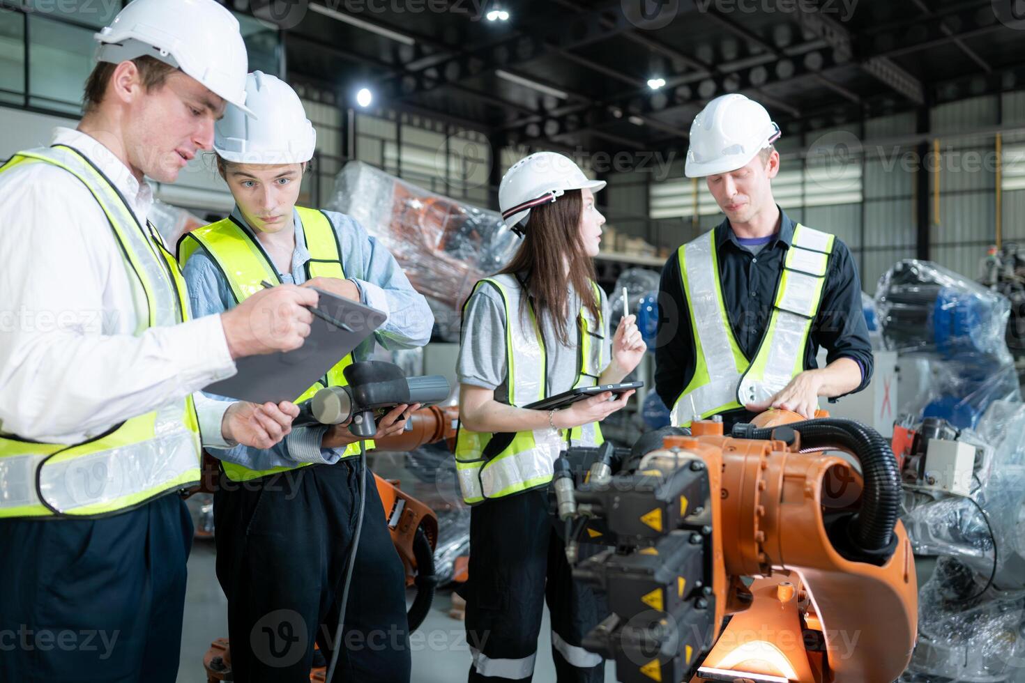 Group of engineers and technicians working together in a robotic arm factory. Inspecting robot arm before delivering to customers photo