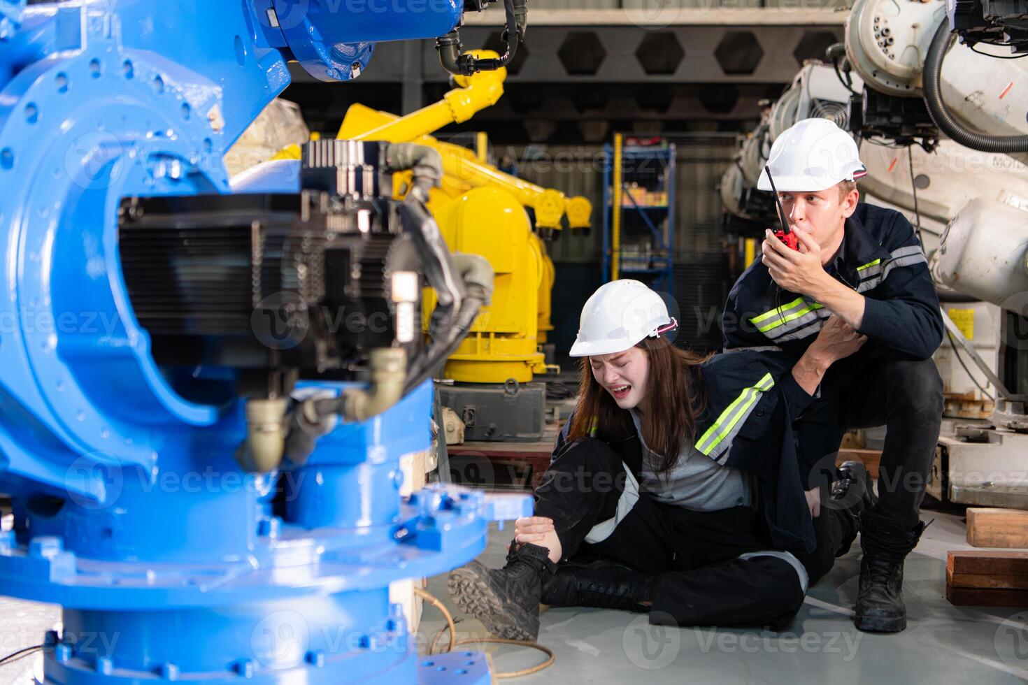 A female worker suffered a leg accident while working in robotic arms factory and male technician asking for first aid assistance photo