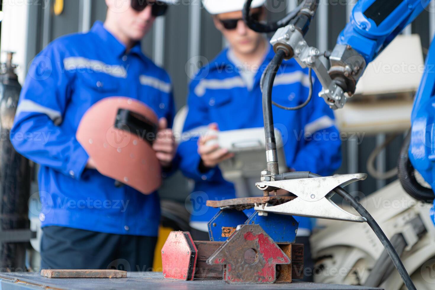 Industrial workers working with robotic arm welding machine in factory, Robotic arm welding industry and engineering concept. photo
