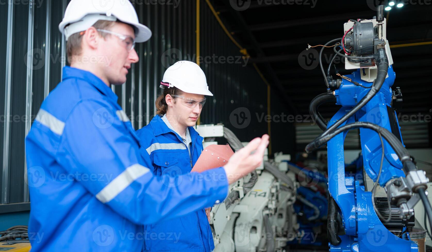 Industrial workers working with robotic arm welding machine in factory, Robotic arm welding industry and engineering concept. photo