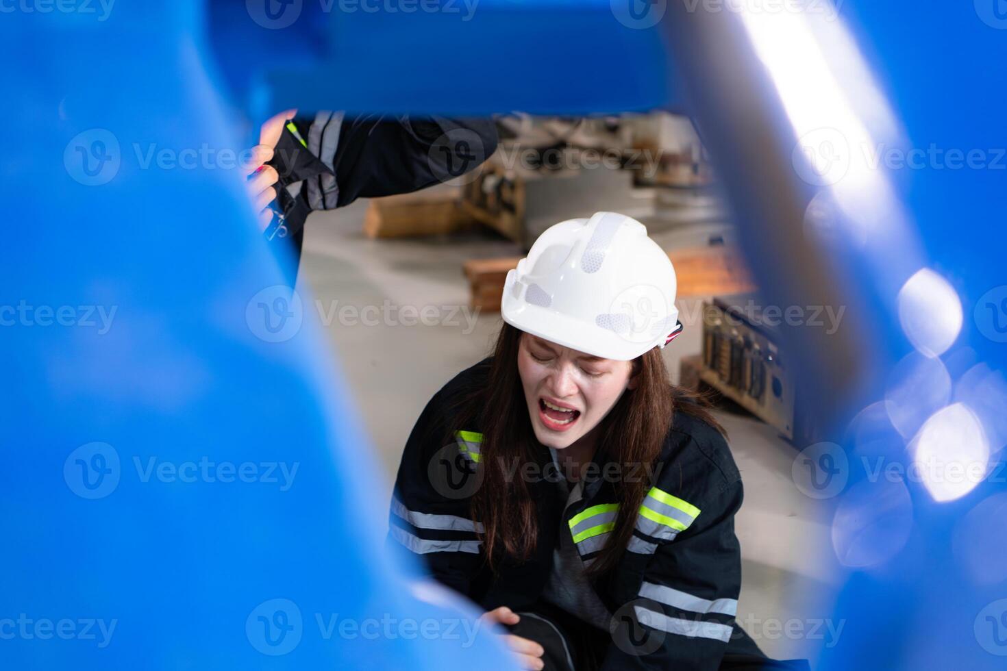 A female worker suffered a leg accident while working in robotic arms factory and male technician is helping and providing first aid. photo