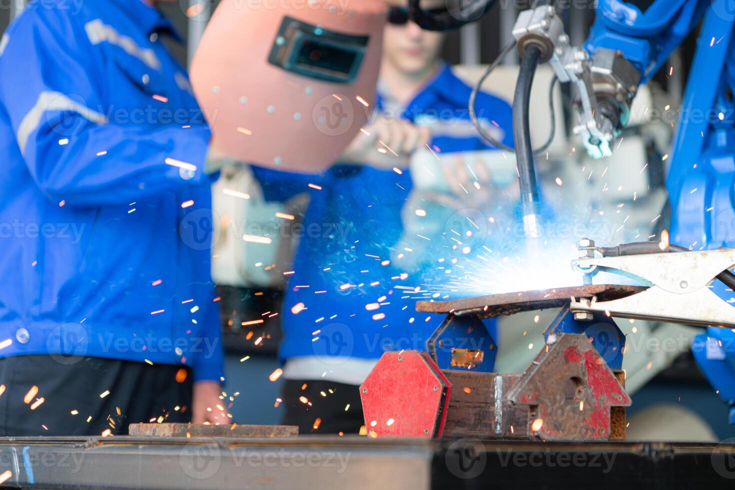 Industrial workers working with robotic arm welding machine in factory, Robotic arm welding industry and engineering concept. photo
