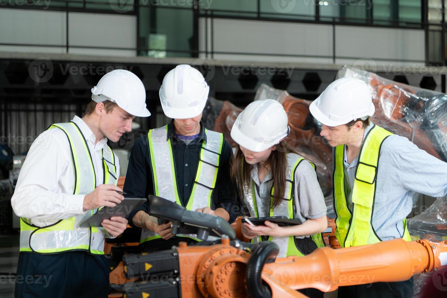 Group of engineers and technicians working together in a robotic arm factory. Inspecting robot arm before delivering to customers photo