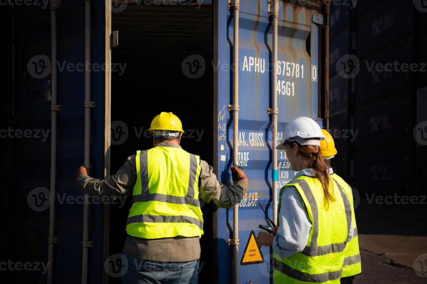 Group of workers in an empty container storage yard, The condition of the old container is being assessed to determine whether it requires maintenance for usage. photo