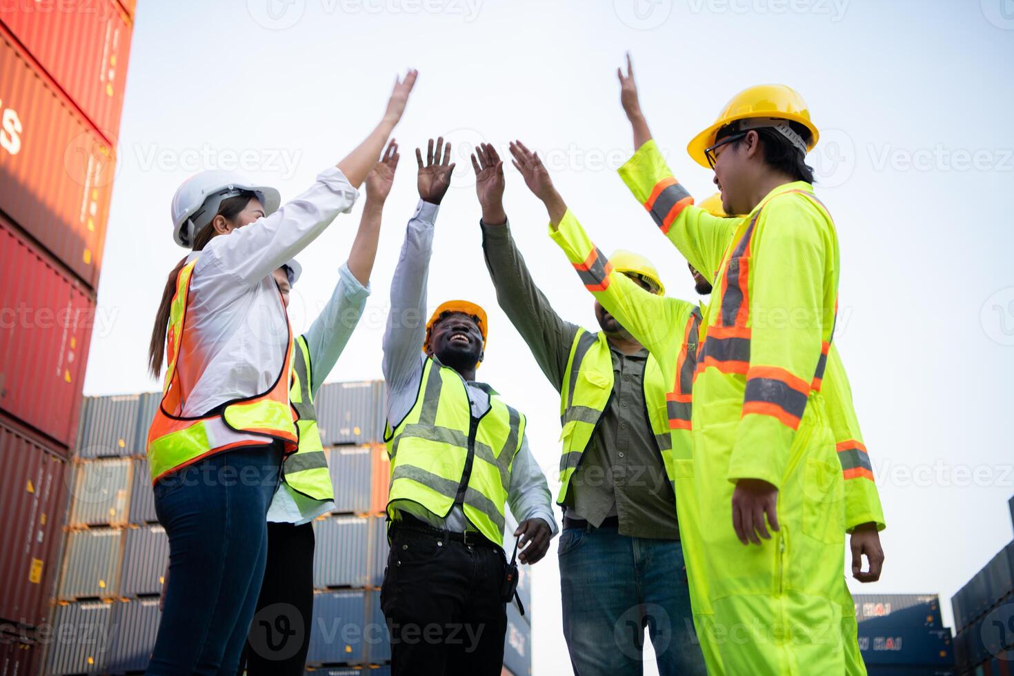 A group of happy team workers stood hand in hand to show their strength and power to start work, In the container storage yard photo