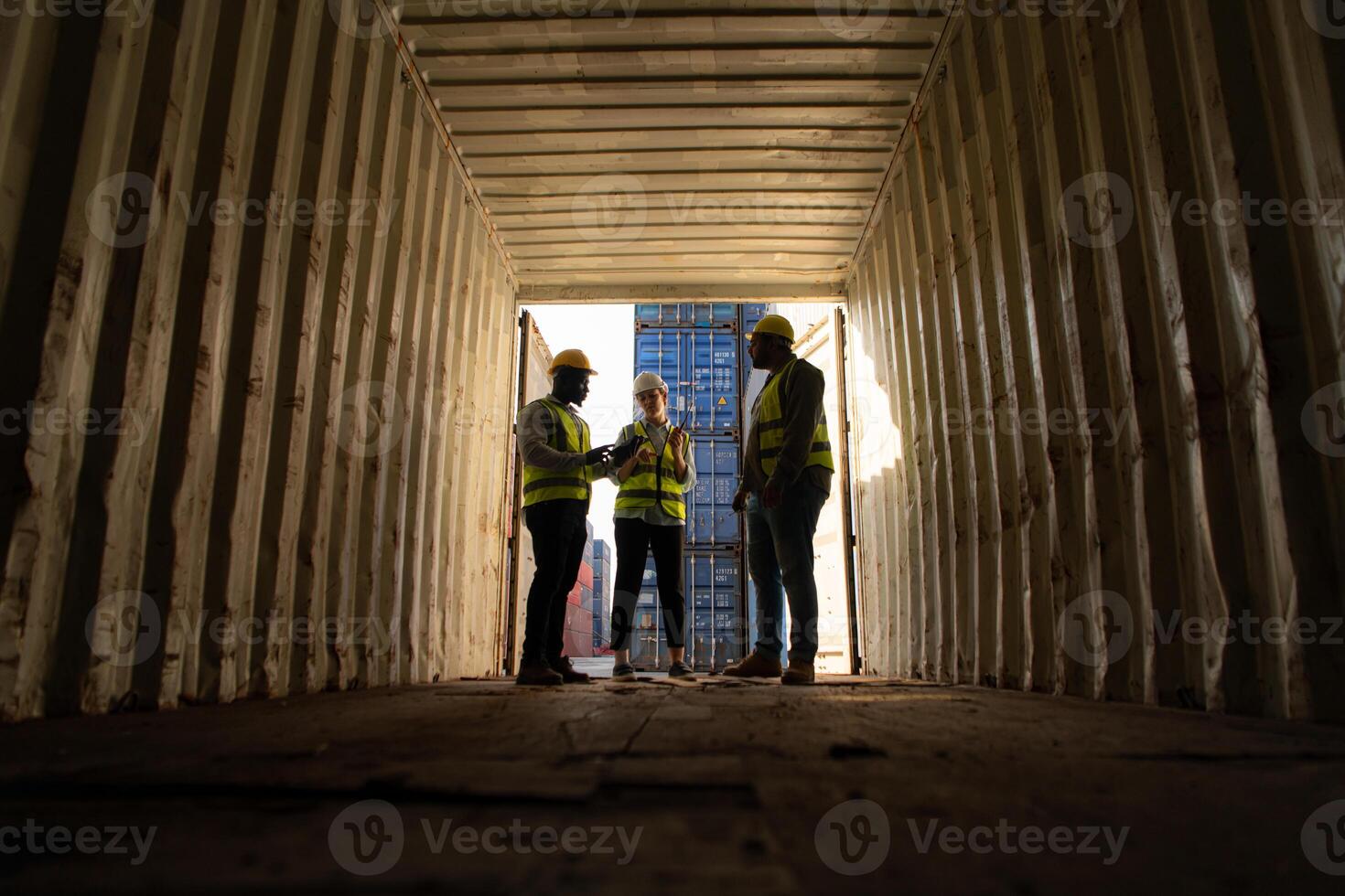 Group of workers in an empty container storage yard, The condition of the old container is being assessed to determine whether it requires maintenance for usage. photo