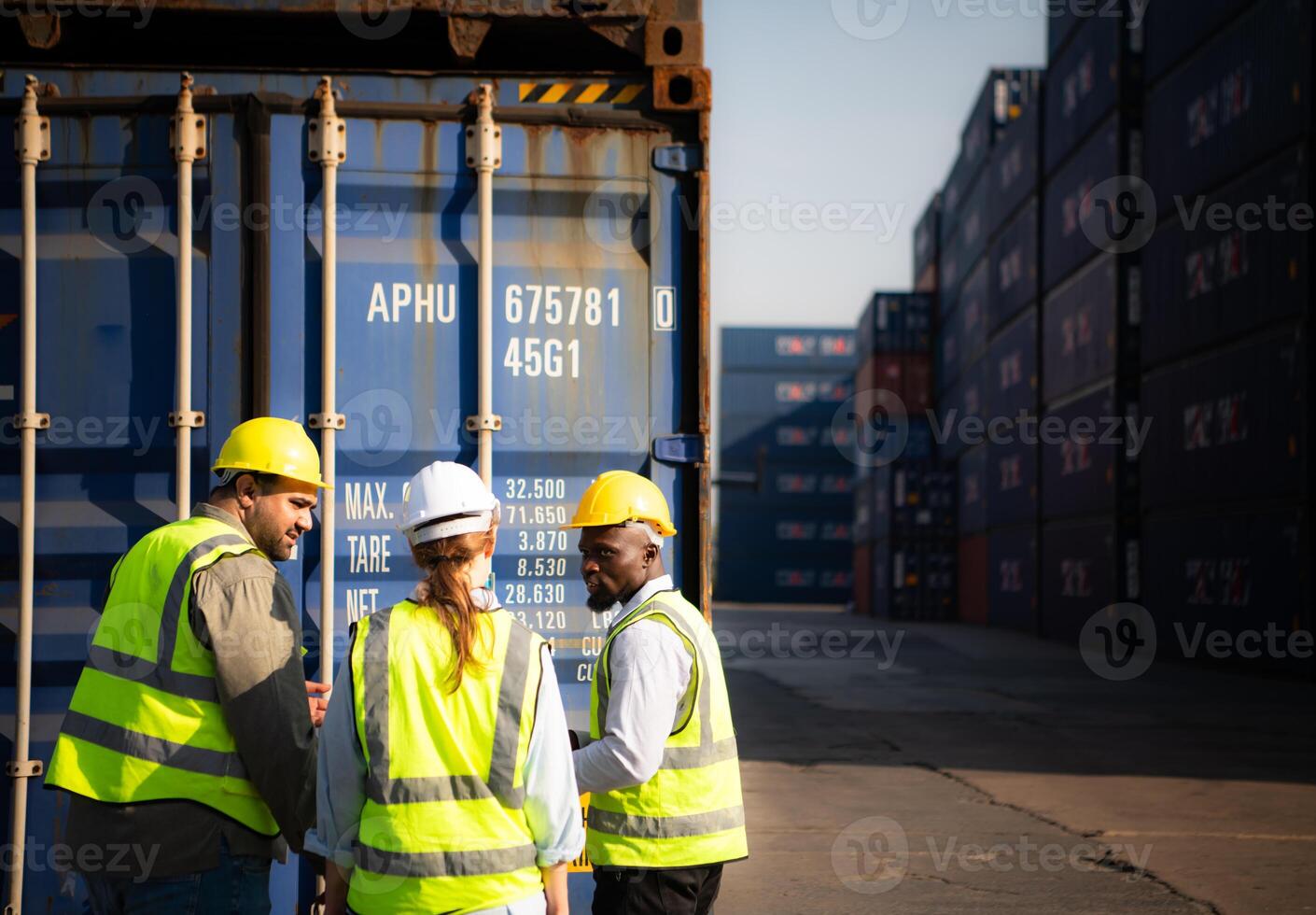 Group of workers in an empty container storage yard, The condition of the old container is being assessed to determine whether it requires maintenance for usage. photo