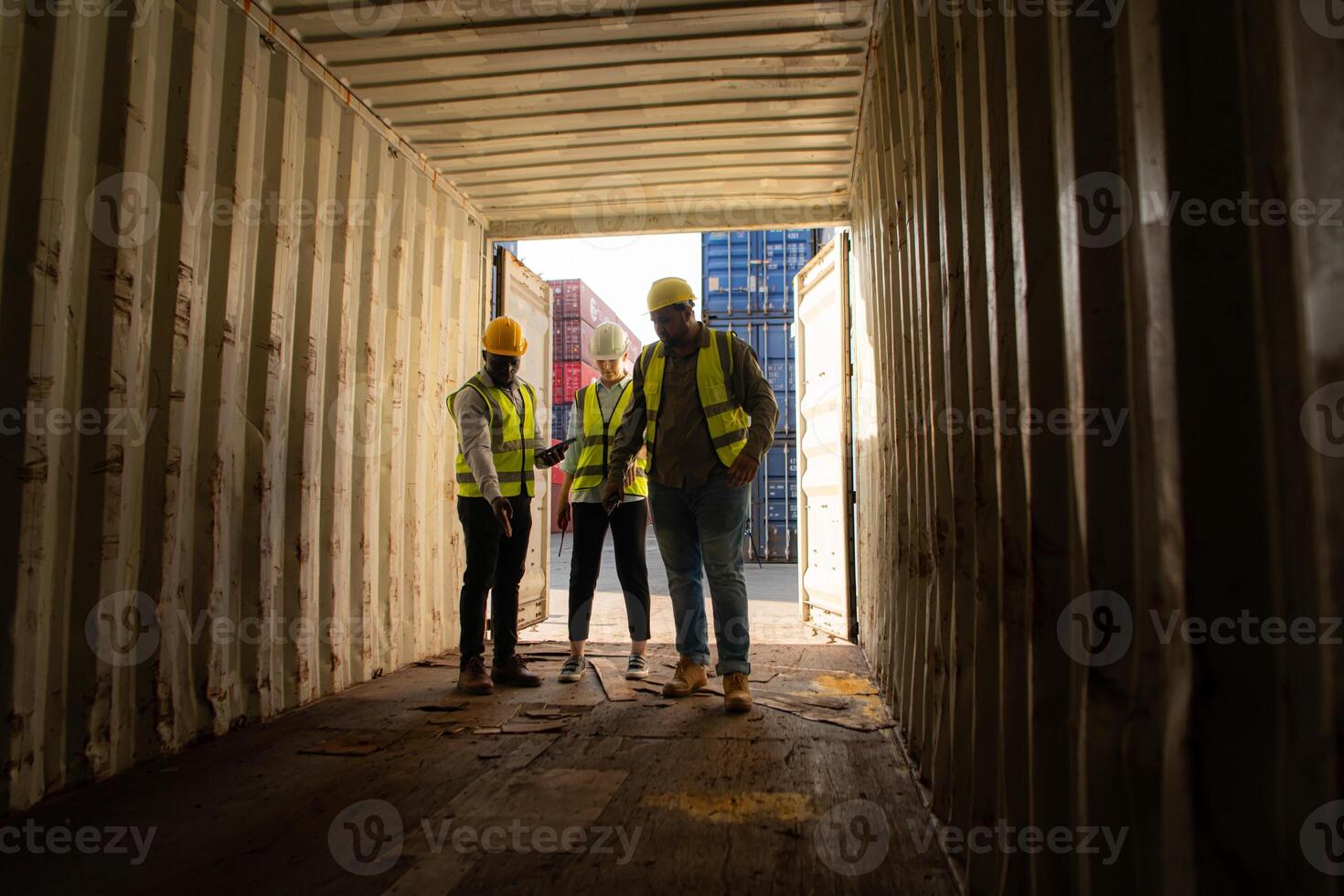 Group of workers in an empty container storage yard, The condition of the old container is being assessed to determine whether it requires maintenance for usage. photo