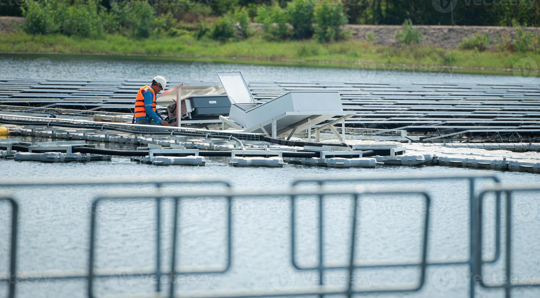 Both of technicians are currently evaluating and repairing the transmission terminals for electricity generated by solar energy in a floating solar power system. photo