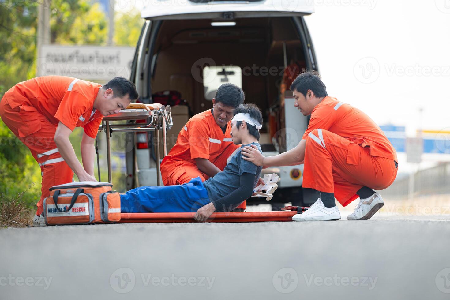 The paramedic  is assisting an injured man in an emergency situation on the road. photo
