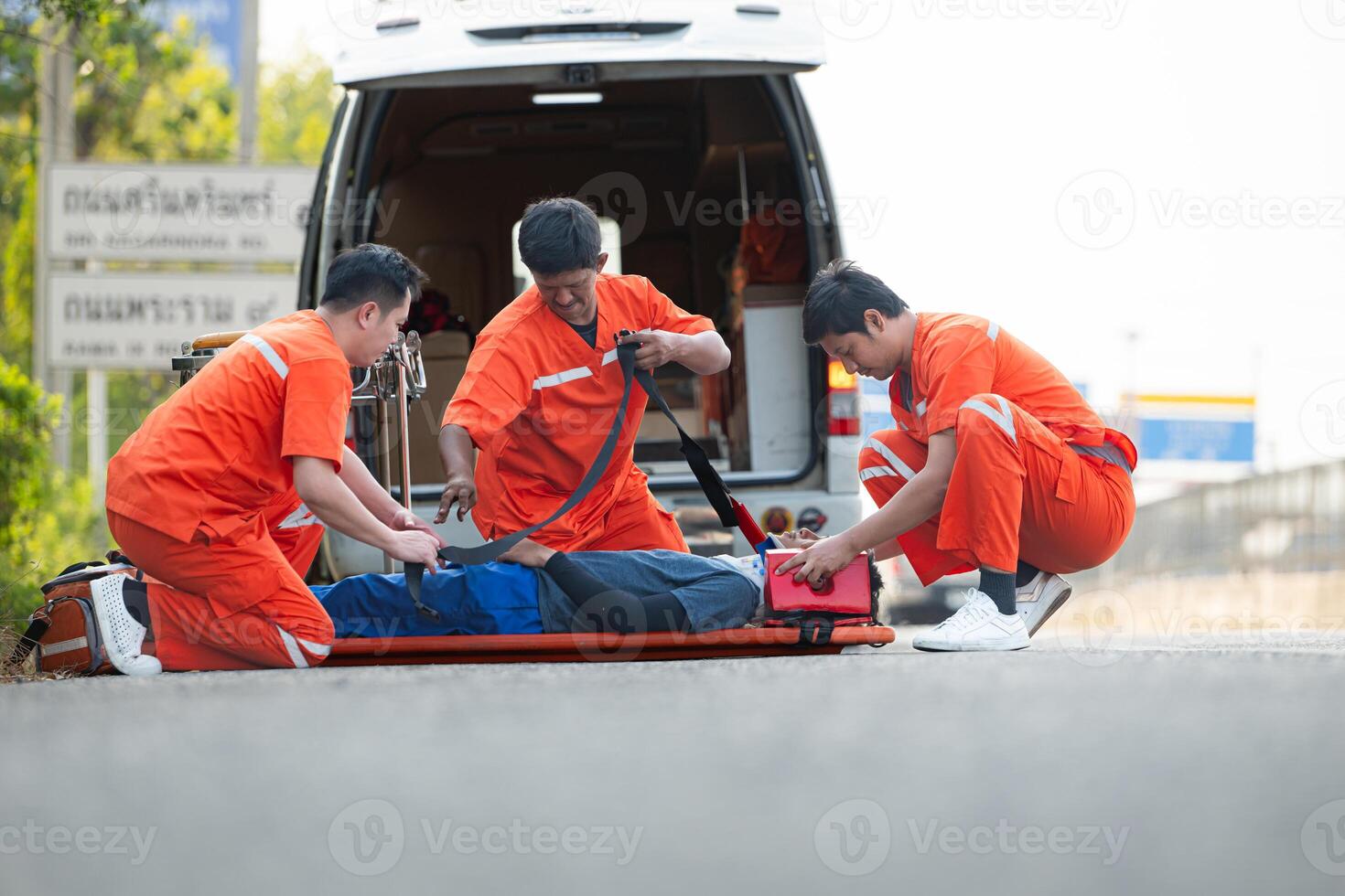 The paramedic  is assisting an injured man in an emergency situation on the road. photo