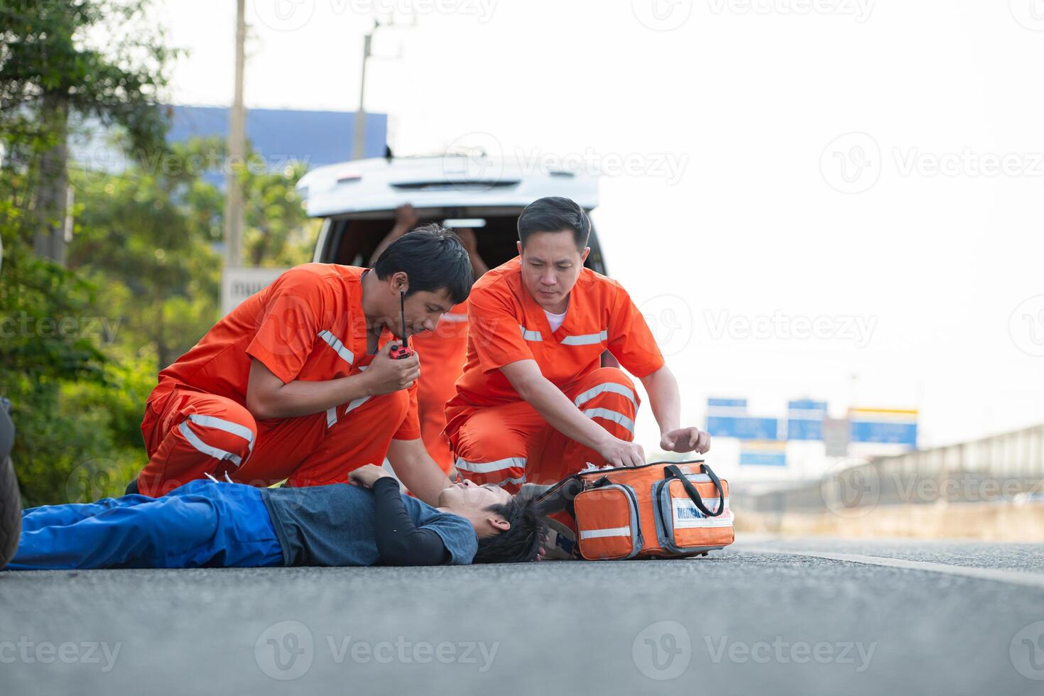 The paramedic  is assisting an injured man in an emergency situation on the road. photo