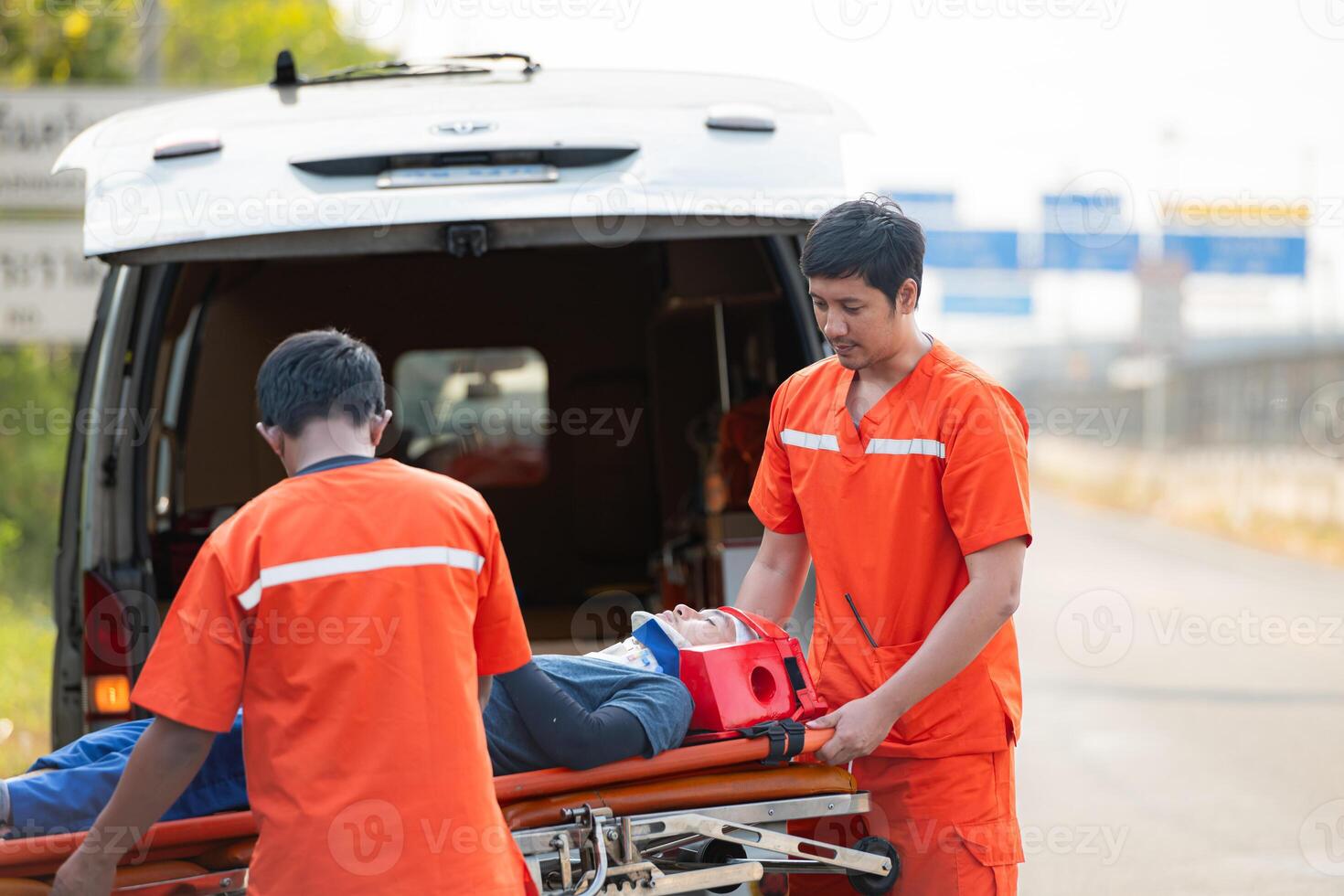 The paramedic  is assisting an injured man in an emergency situation on the road. photo