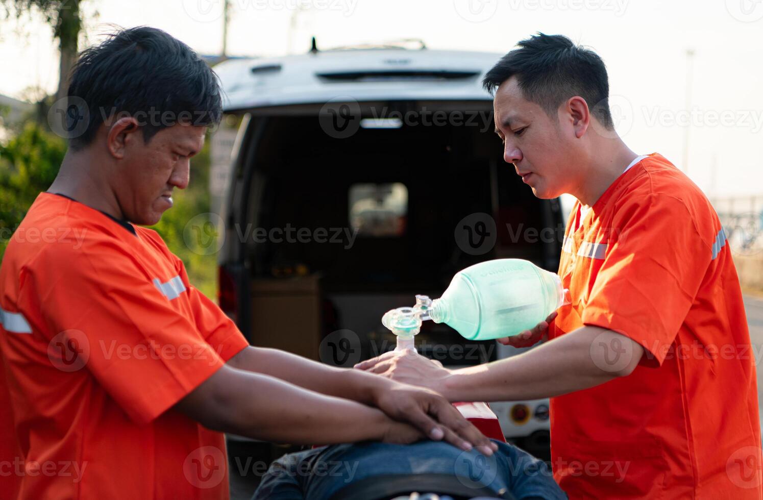 Asian paramedic giving oxygen mask to a patient in emergency situation. photo