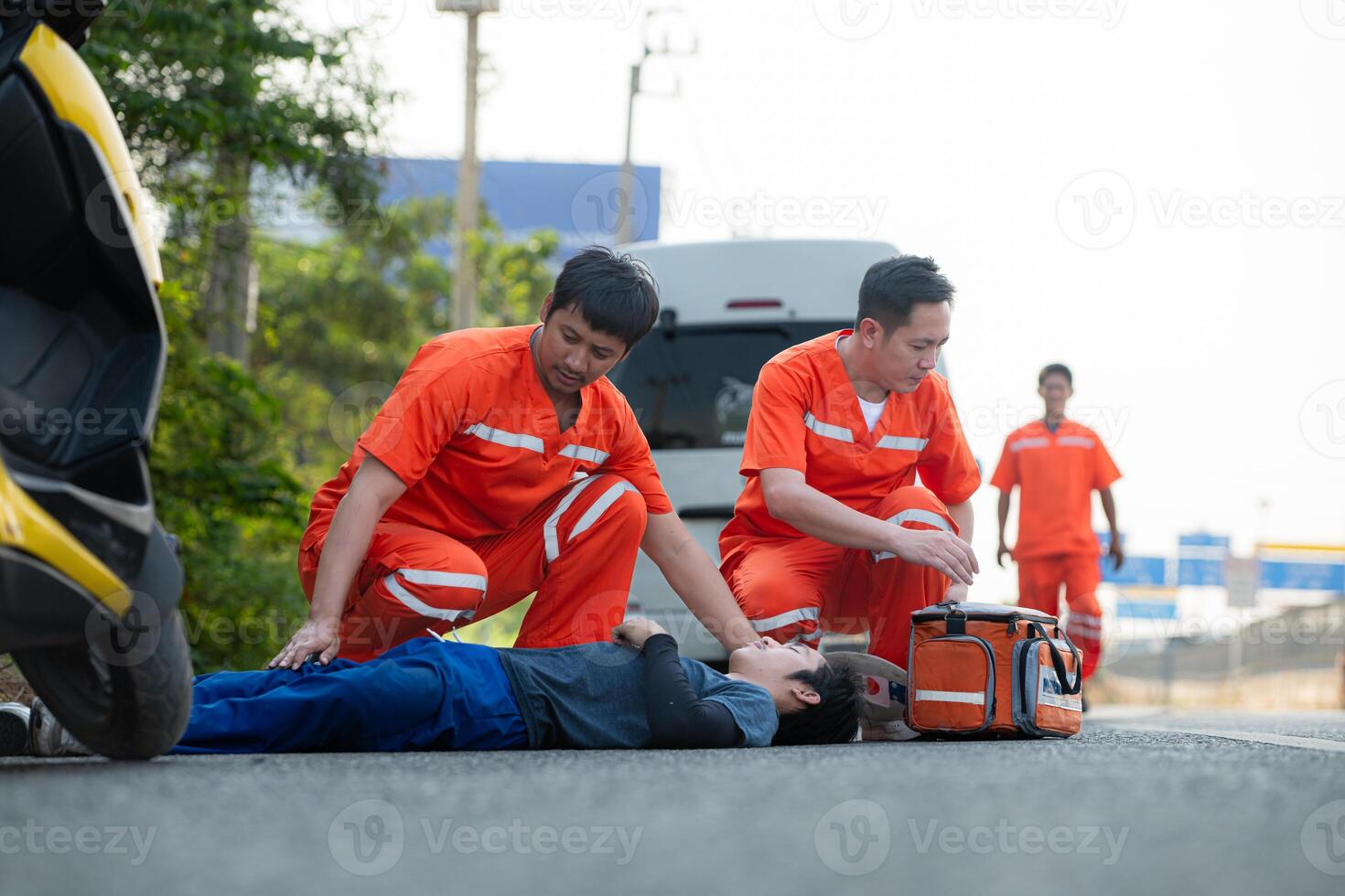 The paramedic  is assisting an injured man in an emergency situation on the road. photo