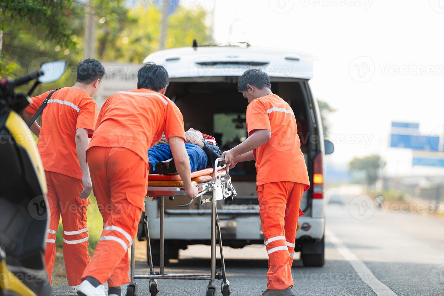 The paramedic  is assisting an injured man in an emergency situation on the road. photo