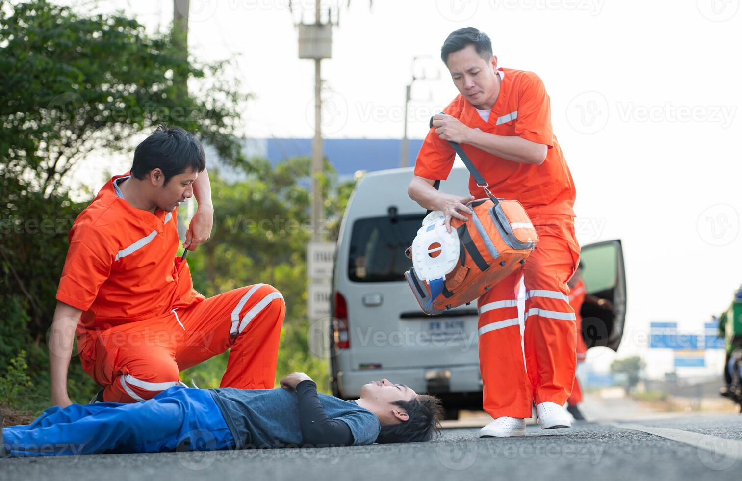 The paramedic  is assisting an injured man in an emergency situation on the road. photo