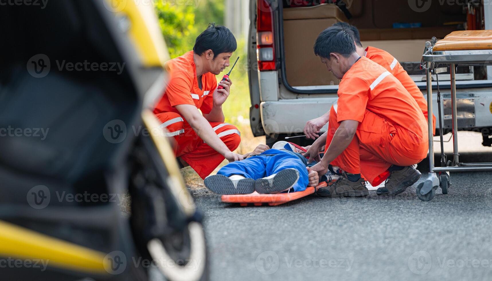 The paramedic  is assisting an injured man in an emergency situation on the road. photo