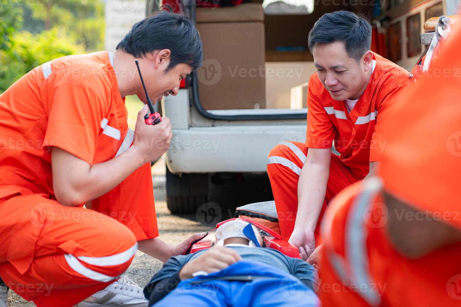 The paramedic  is assisting an injured man in an emergency situation on the road. photo